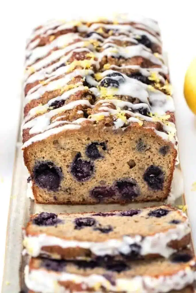 Sliced blueberry banana bread topped with fresh blueberries and banana slices