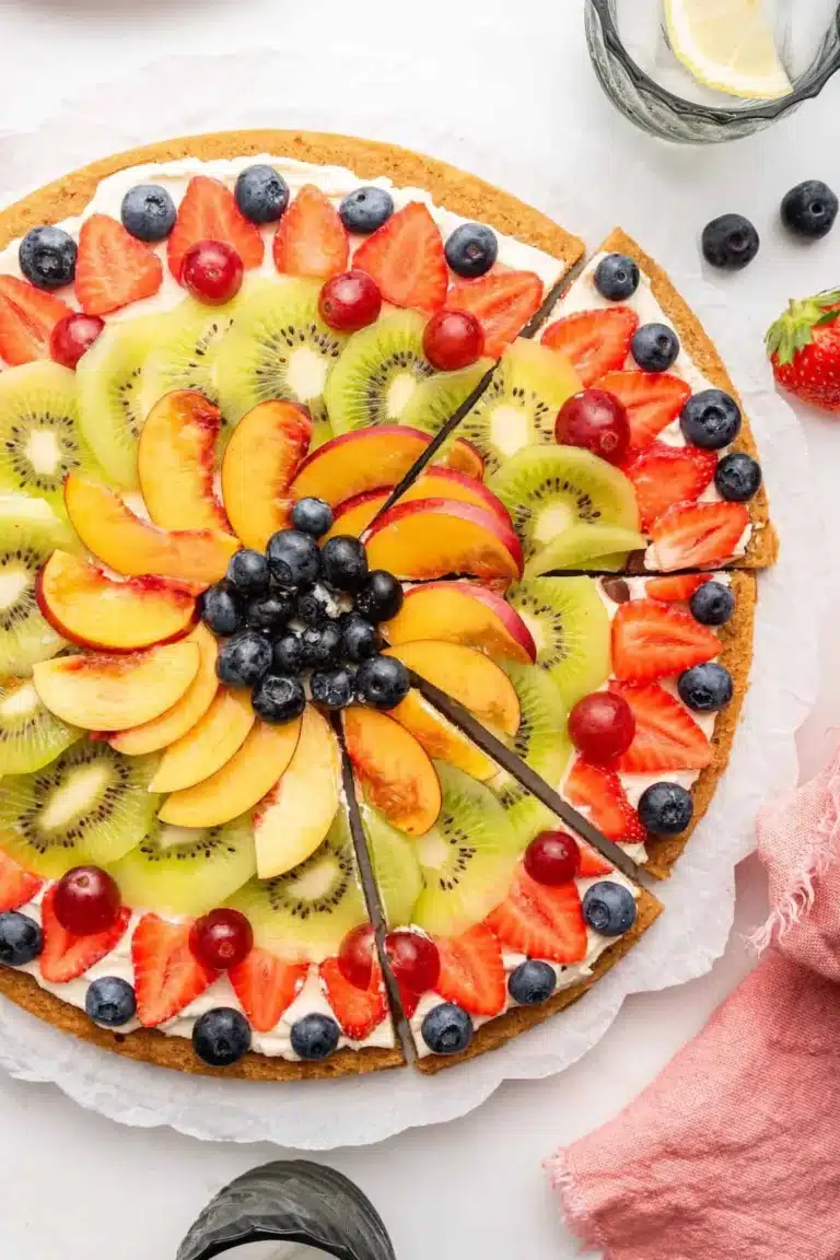Delicious fruit pizza topped with fresh seasonal fruits and creamy frosting