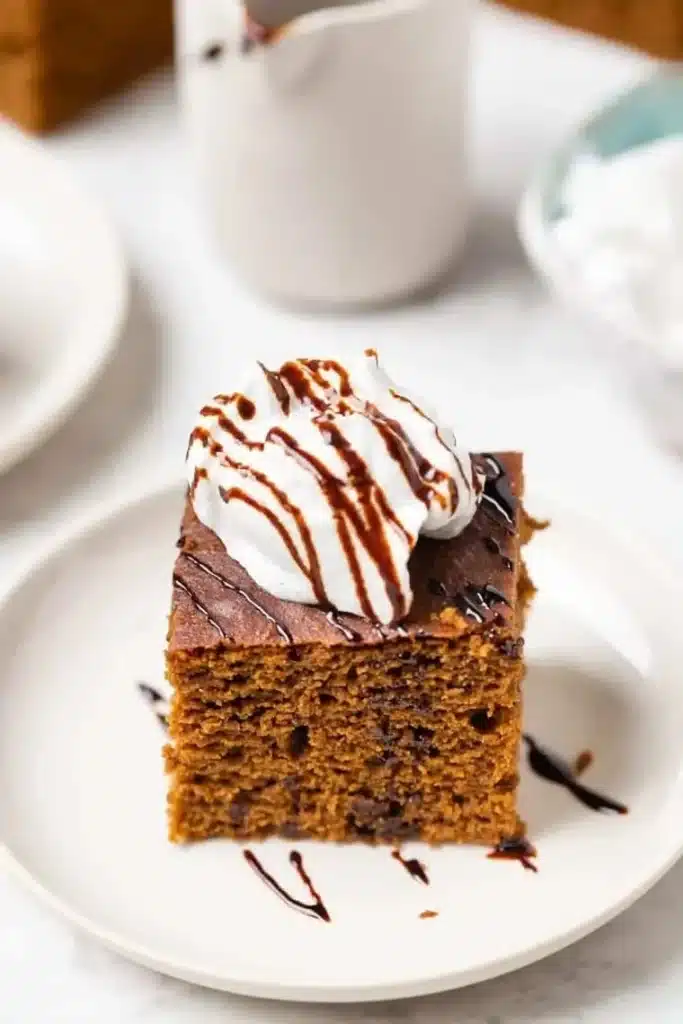 Slice of gluten-free gingerbread cake topped with frosting