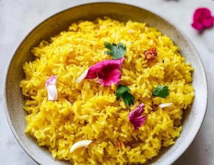Bowl of 20-Minute Garlic Turmeric Rice garnished with fresh herbs