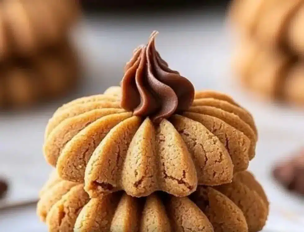 Plate of homemade Peanut Butter Blossoms cookies topped with chocolate kisses.