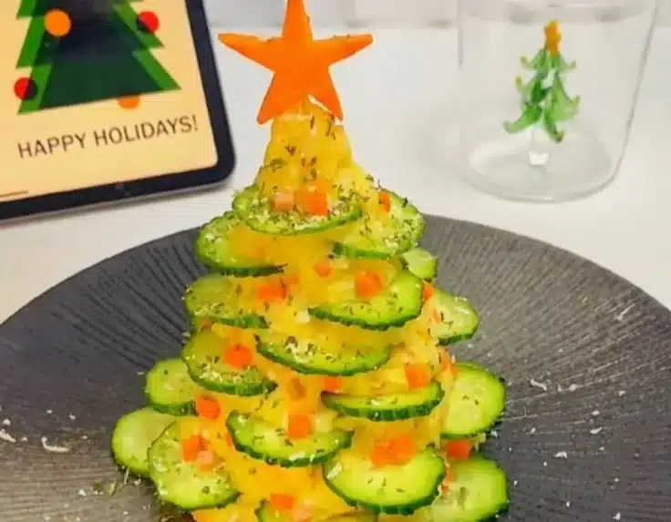 Festive potato salad shaped like a Christmas tree, decorated with vegetables.
